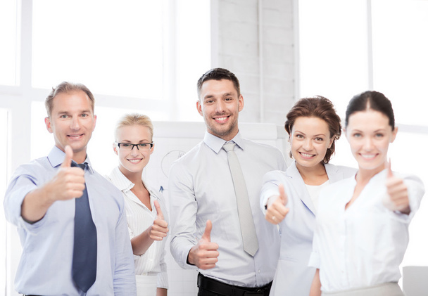 Business team showing thumbs up in office - Photo, image