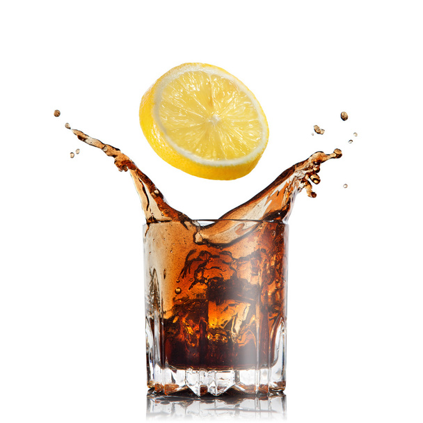 splash of cola in glass with lemon isolated on white - Foto, afbeelding