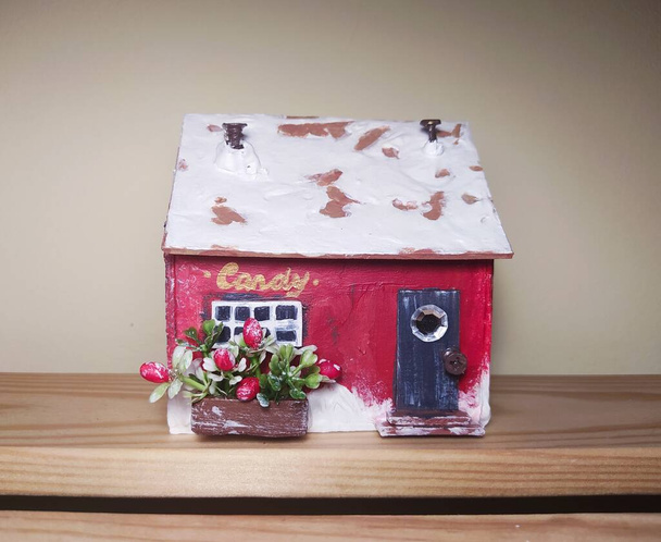 Red christmas house made of cardboard. New year decoration. Miniature of candy shop - Photo, Image
