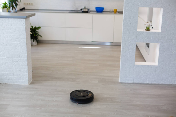 Robotstofzuiger op laminaat houten vloer smart cleaning technologie - Foto, afbeelding