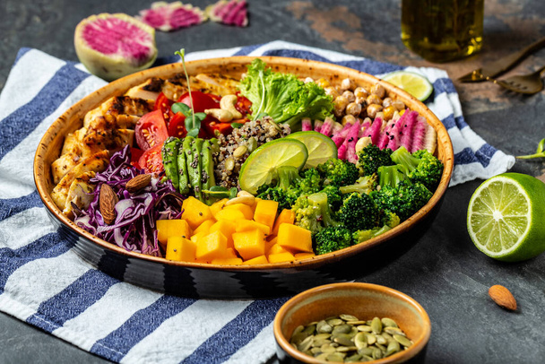 Чаша Будды со свежими овощами, филе курицы, киноа, авокадо, горох, редис арбуза и орехи, здоровое сбалансированное питание на обед. - Фото, изображение