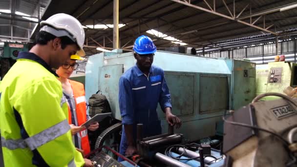 Ingenieurs en geschoolde technici werken in een grote machinaal bediende industriële faciliteit. - Video