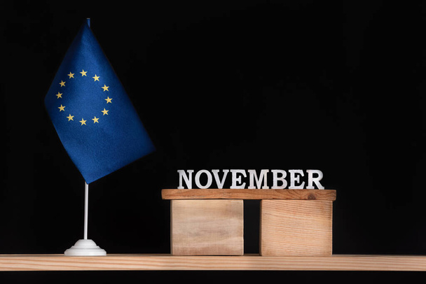Calendario in legno di novembre con bandiera UE su sfondo nero. Unione europea Date di novembre. - Foto, immagini