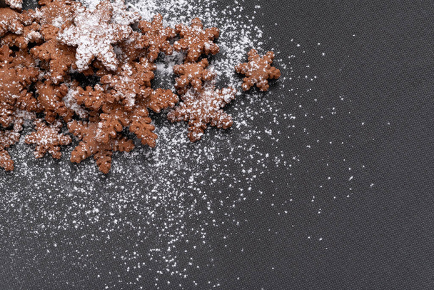Sterrenvormige peperkoek koekjes bestrooid met poedersuiker op een grijze achtergrond - Foto, afbeelding