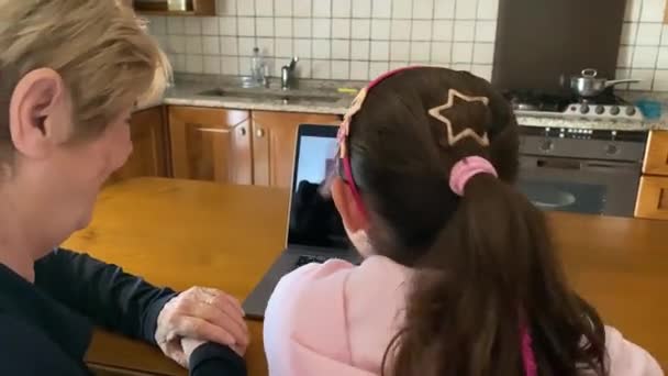 Giovane ragazza con sua nonna in un videocall con i loro genitori - Filmati, video
