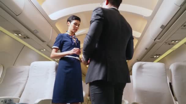 A légiutas-kísérő személyzet üdvözli az utasokat a repülőgépen - Felvétel, videó