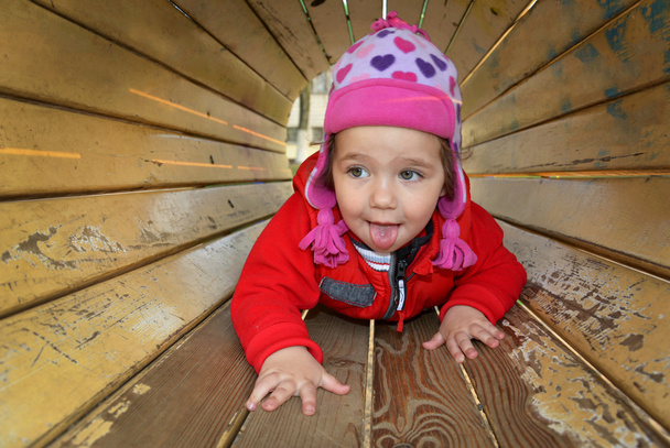 Маленька дівчинка грає на дитячому майданчику і сміється
. - Фото, зображення