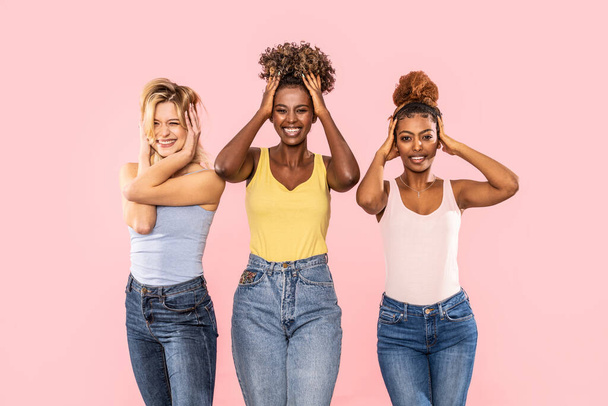 Funny photo of three multiracial women posing on pink studio background, smiling and having fun together. Happy lifestyle concept. - Fotoğraf, Görsel