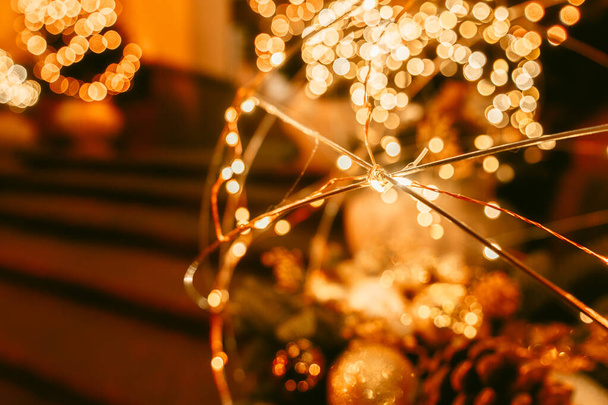 Luz borrada do bokeh de uma bola de Natal dourada. Brilho abstrato de estrelas e faíscas intermitentes. - Foto, Imagem