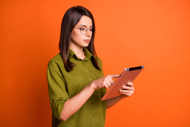 Photo portrait of focused brunette freelancer working typing on tablet isolated on vivid orange color background - Φωτογραφία, εικόνα