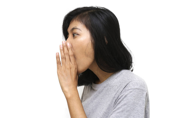 Молодая азиатка изолировала белый фон рукой в рот, рассказывая секретные слухи, шепча злобные разговоры - Фото, изображение