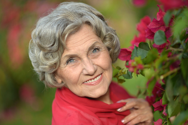 Older woman with flowers - Foto, afbeelding