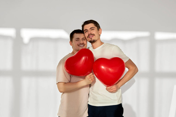 Gay couple of men with balloons in the shape of hearts - Foto, imagen