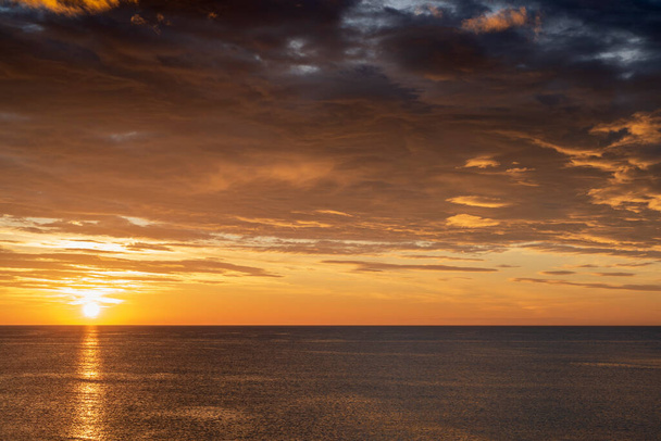 早朝の日の出と壮大な曇天の海の上。スペインのアリカンテ、トルレビエハの海岸。地中海2019. - 写真・画像