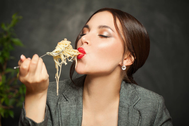 Happy woman eating italian pasta spaghetti on black background - Φωτογραφία, εικόνα