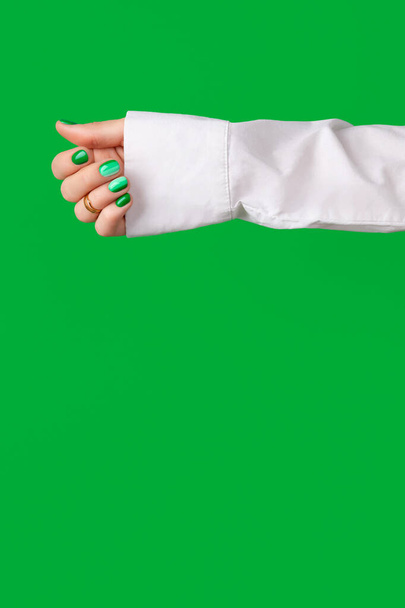 Krásné upravené ženské ruce s jarní letní nehet design na zeleném pozadí. Manikúra, pedikúra, salon krásy. Prázdné místo pro text - Fotografie, Obrázek