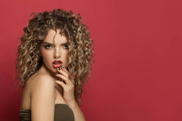 Fashion portrait of perfect young woman with curly hair on red background - Photo, Image