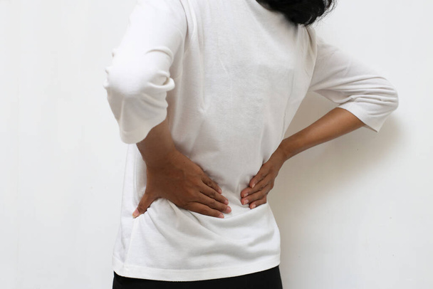 Νεαρή Ασιάτισσα που υποφέρει από πόνο στην πλάτη και οσφυϊκό πόνο στη μέση - Φωτογραφία, εικόνα