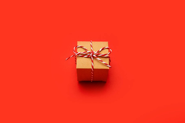 Christmas gift on a colored red background top view. New Year, holiday, give, pack. - Фото, зображення
