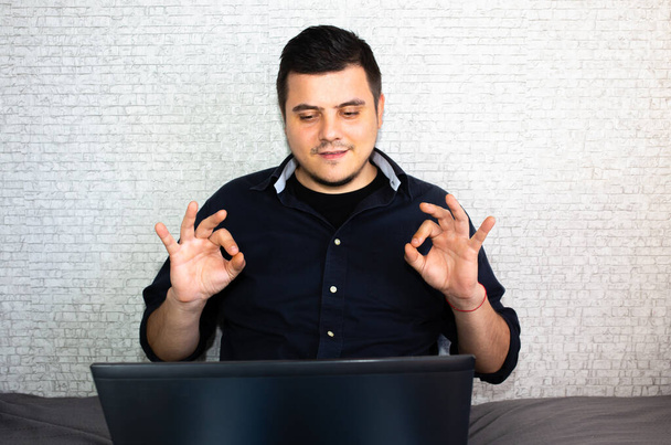 Der Mensch kommuniziert über die Zeichensprache. Guy in der Nähe des Laptops interagiert durch Videoanrufe. Leben mit Behinderung in positivem Licht. - Foto, Bild