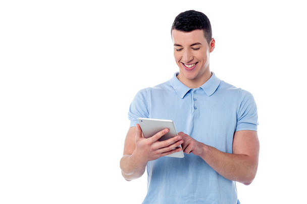 Young man using his tablet pc - Фото, изображение