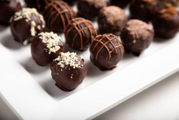 variety of handmade gourmet chocolate truffle candy on a white plate - Foto, Imagem