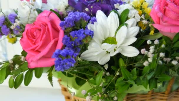 Ein schöner stilvoller Strauß aus verschiedenen bunten Blumen von Gänseblümchen, Rosen, Trockenblumen. Festlicher Brautstrauß aus weißen, rosa, blauen, lila, gelben Blumen - Filmmaterial, Video