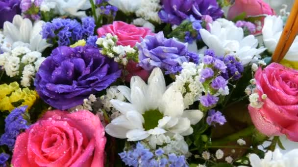 Egy gyönyörű, elegáns csokor különböző színes virágok százszorszépek, rózsák, szárított virágok. Ünnepi menyasszonyi csokor fehér, rózsaszín, kék, lila, sárga virágokból - Felvétel, videó