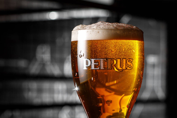 Брюгге, Бельгия - 20 Ocober, 2019: Бокал бельгийского пива Петрус в баре - Фото, изображение