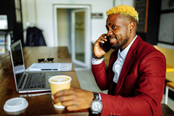 cheerful businessman entrepreneur talking mobile phone and writing note at office - Φωτογραφία, εικόνα