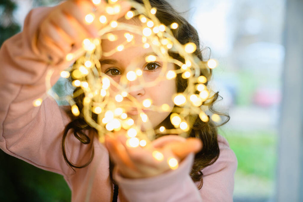 Retrato de niña con luces de guirnalda de Navidad - Foto, Imagen