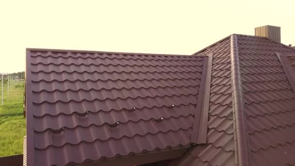 Kahverengi metal kiremitlerle kaplı evin çatı yapısının havadan görünüşü. - Video, Çekim
