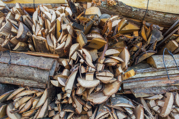 Bündel gespaltener Rundhölzer, die als Brennholz verkauft werden. Nahaufnahme - Foto, Bild