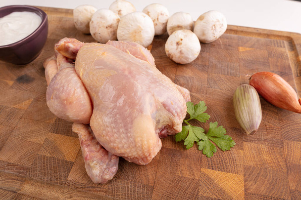 Ingredient for cooking a cockerel on a cutting board on a white background - Фото, зображення