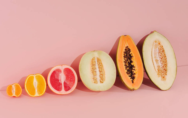 Δημιουργική σύνθεση με καλοκαιρινά εξωτικά φρούτα. Φόντο σε ροζ χρώματα. Έννοια τροφίμων, οριζόντιος προσανατολισμός με χώρο για κείμενο. - Φωτογραφία, εικόνα