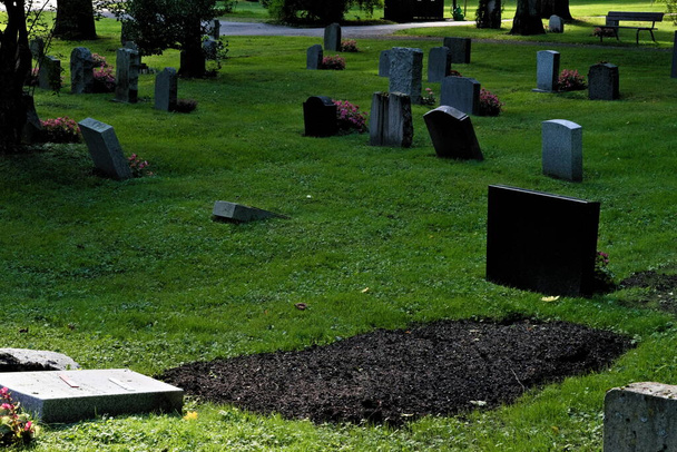 Недавно вырытая могила на кладбище летом. - Фото, изображение