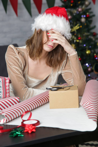 Depressed frustrated woman wrapping Christmas gift boxes, winter holiday stress concept - Foto, Imagem
