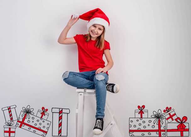 Smiling little girl beside christmas presents - Foto, Imagem