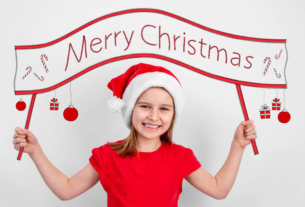 Little girl holding merry christmas slogan - 写真・画像