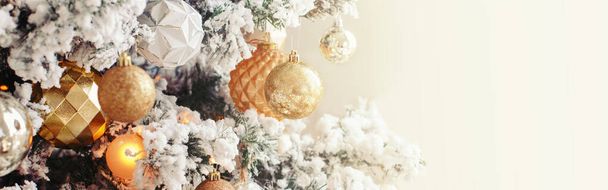 С праздником. Счастливого Рождества. Новогодний заголовок веб-баннера. Украшенная елка для зимних праздников. Золотые и белые украшения безделушки с огнями и искусственным снегом.   - Фото, изображение