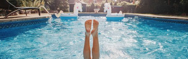 Funny child diving in swimming pool on home backyard. Kid child enjoying having fun in water. Summer outdoor water activity for kids. Legs up in the air in pool. Web banner header. - Photo, Image
