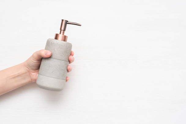 Soap dispenser bottle in female hand on white background top view. - Foto, Imagem