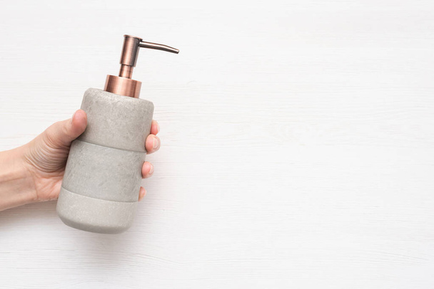 Soap dispenser bottle in female hand on white background top view. - Foto, Imagem