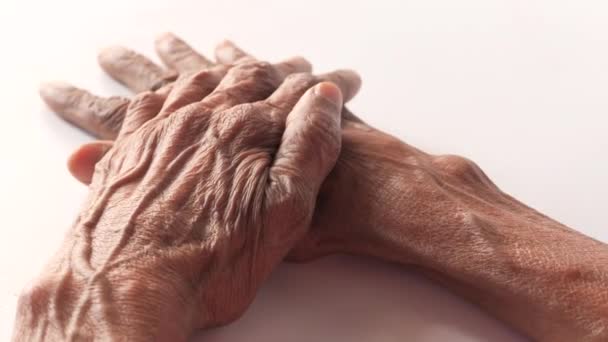 ηλικιωμένες γυναίκες που αγγίζουν το χέρι τους σε λευκό φόντο  - Πλάνα, βίντεο