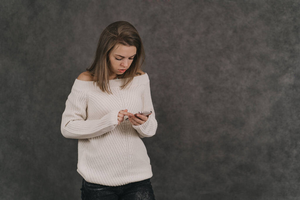 Dívka drží telefon v rukou. Závislost na sociálních sítích. Celý život v pomůckách - Fotografie, Obrázek