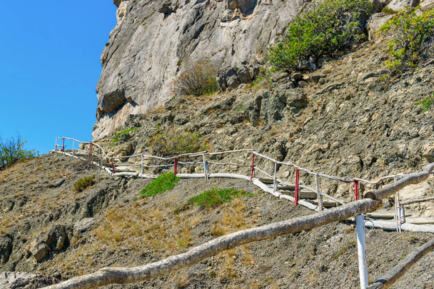 Wooden pedestrian staircase on the rock. The famous Golitsyn trail in the Novy Svet in Crimea - Фото, зображення