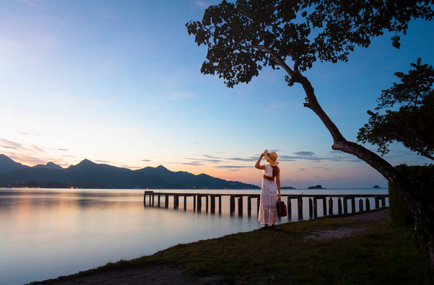 Женщина-путешественница на деревянном мосту на фоне горного восхода солнца. Ко Чанг, Трат, Таиланд, Азия - Фото, изображение