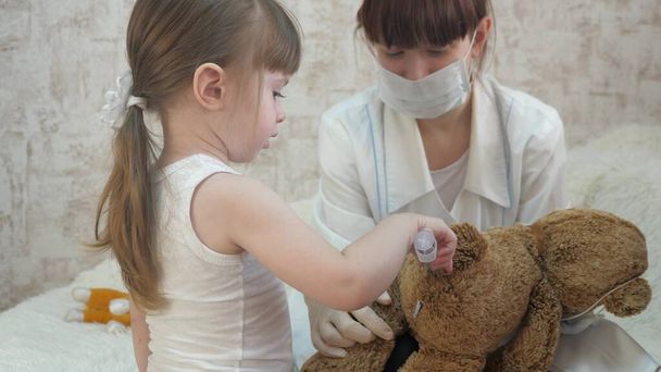 Çocuklar doktorculuk oynuyor, hemşire, aşı ile tedavi ediliyor. Küçük çocuk oyuncak hayvanlara iğne yapıyor. Küçük kız hastanede annesiyle oynuyor. Sağlıklı kız ve oyuncak ayı. Çocuk hastanede oynuyor.. - Fotoğraf, Görsel