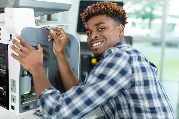 concentrated man fixing a printer - Φωτογραφία, εικόνα