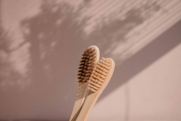 Zero waste bamboo toothbrush on pastel background with floral shades. Высокое качество фото - Фото, изображение